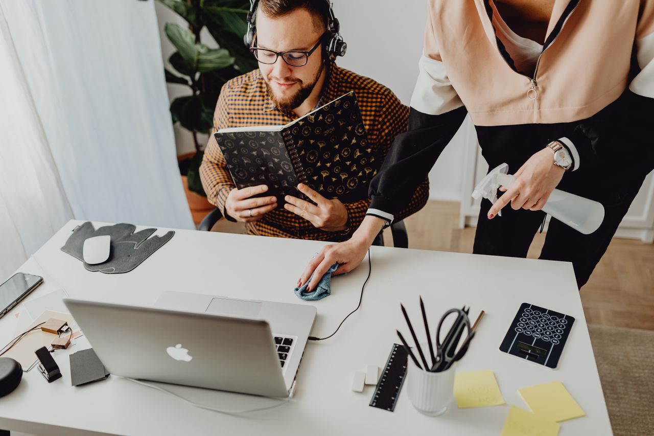 Des collègues échangent dans un bureau moderne, où la technologie se mêle à l’hygiène au travail.